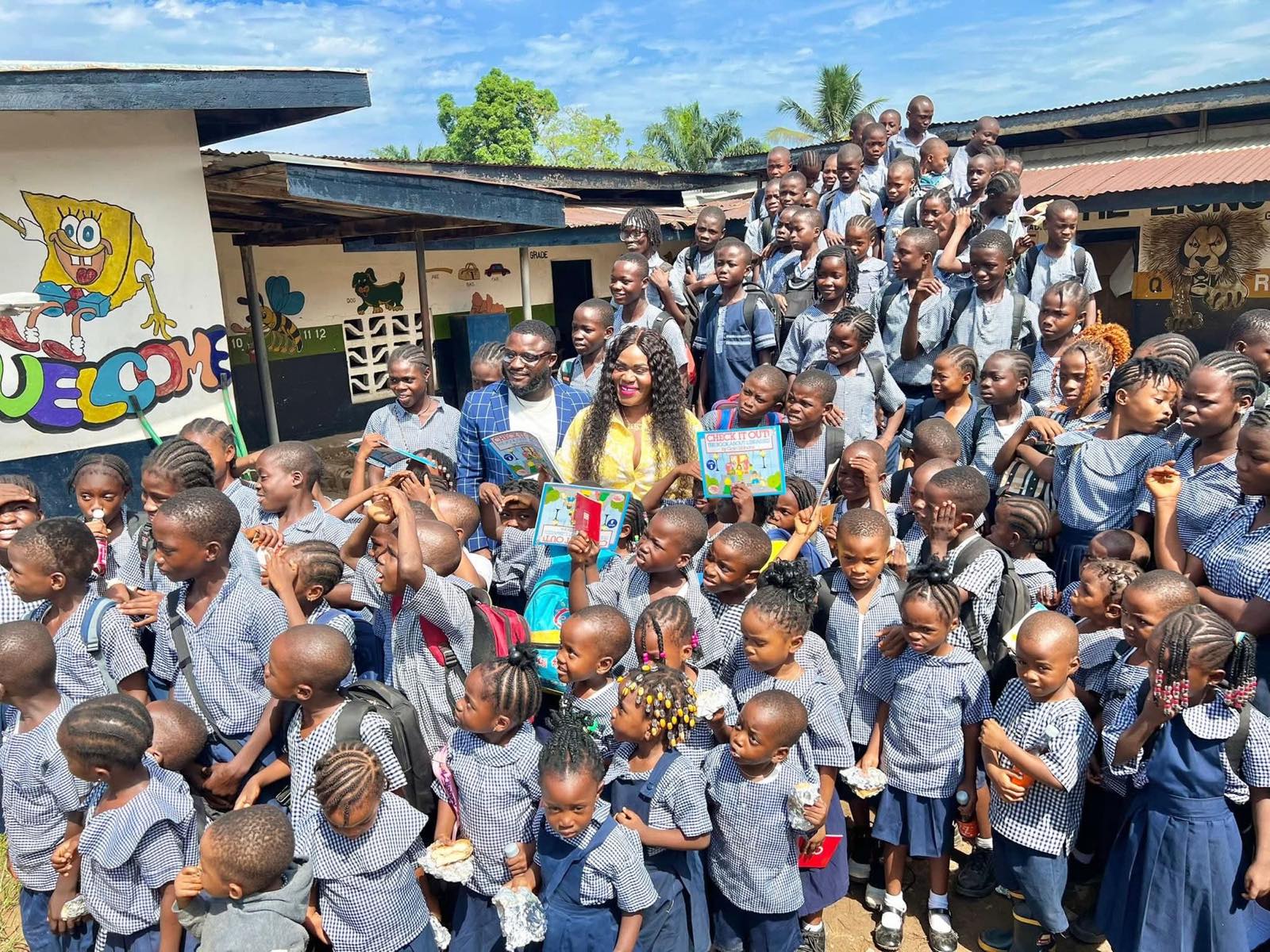 Fate and Kemah Tapson surrounded by schoolchildren during a Friends of Tapson school visit in Liberia